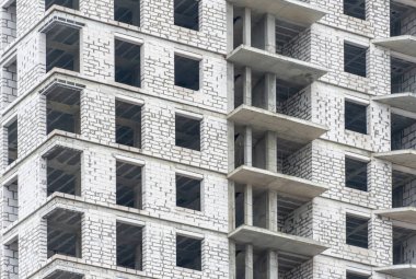 Yeni modern bina inşaatı. Köpük beton blok ve çakışmadan oluşan çok katlı bir mühendislik tasarımı. Pencereleri ve balkonu olan yüksek katlı bir daire. Yeni evin inşaatı.