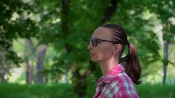 Frau Mit Brille Und Rosafarbenem Hemd Spaziert Durch Laubbäume Mittlerer — Stockvideo