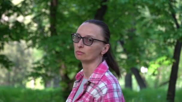 Frau Mit Brille Und Rosafarbenem Hemd Spaziert Durch Laubbäume Mittlerer — Stockvideo