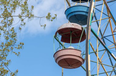 Lunaparktaki eski renkli dönme dolap. Mavi gökyüzü arka planında çok renkli Sovyet atlıkarınca. Entertainment High Circle şehirde döner. Aile için bayramın yuvarlak eğlenceleri. Geleneksel eğlence.