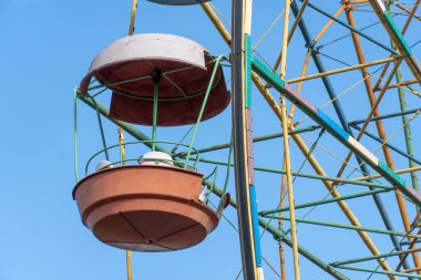 Lunaparktaki eski renkli dönme dolap. Mavi gökyüzü arka planında çok renkli Sovyet atlıkarınca. Entertainment High Circle şehirde döner. Aile için bayramın yuvarlak eğlenceleri. Geleneksel eğlence.