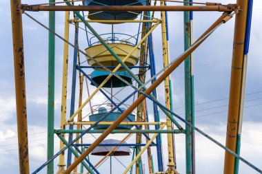 Lunaparktaki eski renkli dönme dolap. Mavi gökyüzü arka planında çok renkli Sovyet atlıkarınca. Entertainment High Circle şehirde döner. Aile için bayramın yuvarlak eğlenceleri. Geleneksel eğlence.