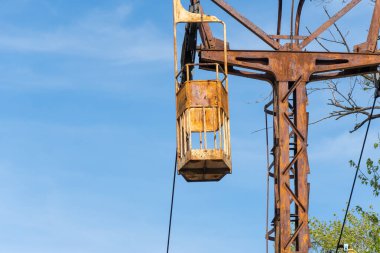 İnsanları eğlence parkına taşımak için terk edilmiş bir kablo. Nehrin karşısındaki eski, eski asma yol. Dnepr şehrinde eski paslı teleferik. Sovyetler Birliği teknolojisi ve çekimleri SSCB.
