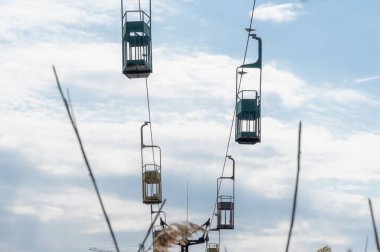 İnsanları eğlence parkına taşımak için terk edilmiş bir kablo. Nehrin karşısındaki eski, eski asma yol. Dnepr şehrinde eski paslı teleferik. Sovyetler Birliği teknolojisi ve çekimleri SSCB.