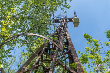 İnsanları eğlence parkına taşımak için terk edilmiş kule kablosu. Nehrin karşısındaki eski, eski asma yol. Dnepr şehrinde eski paslı teleferik. Sovyetler Birliği teknolojisi ve çekimleri SSCB.