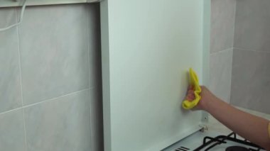 Gaz ocağını temizleyip düzenliyorum. Kadın elleri mutfakta sarı süngerle beyaz yüzeyi siler. Hizmetçi evde ocak yıkıyor. Ev işleri ve ev işleri. Mutfak temiz..