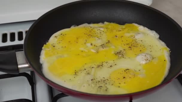 白玉ねぎとスクランブルエッグの健康的な料理を調理します 家庭のキッチンでフライパンで鶏の卵を揚げた タンパク質と黄身は自然な完全な栄養です 家庭用キッチンのガスコンロでの調理 — ストック動画
