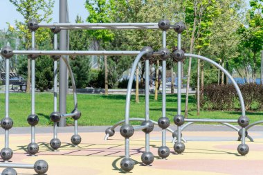 Şehir parkındaki açık hava spor sahasında. Yatay çubuklu, kolonlu ve dengeli sokak egzersiz ekipmanları. Tüm aktif insanlar için sokak jimnastiği. Zindelik ve sağlıklı yaşam tarzı kavramı. Ayrıntılar metal.