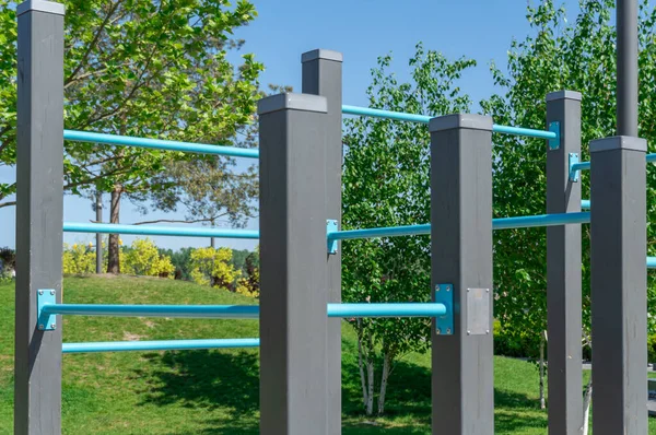 stock image Outdoor sports ground in the city park. Street exercise equipment with horizontal bars, columns and balances. Street gym for all active people. Concept of fitness and healthy lifestyle. Details metal.