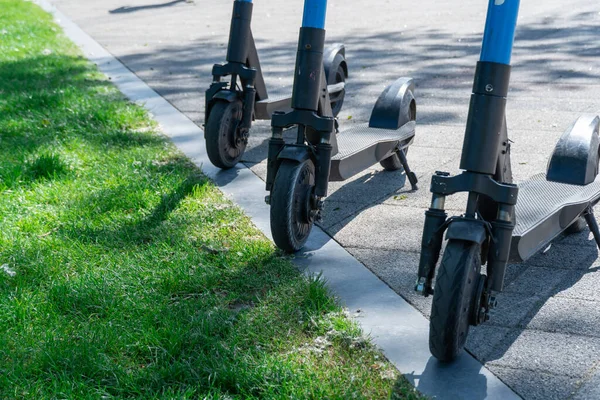 stock image Electric scooter parked on sidewalk in city. Public mobile transport standing in pavement. Rent economical vehicle in contemporary urban. Business technology on rental. Ecological transport. Leisure.