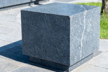 Şehir parkında rahat bir taş bank. Boş zaman için gri sabit koltuk tasarımı. Dışarıdaki boş park tezgahı. Geometri doğa ve dinlenme yeri üzerine. Taş döşeli mobilyalar. Dekorasyon bahçede oturur.