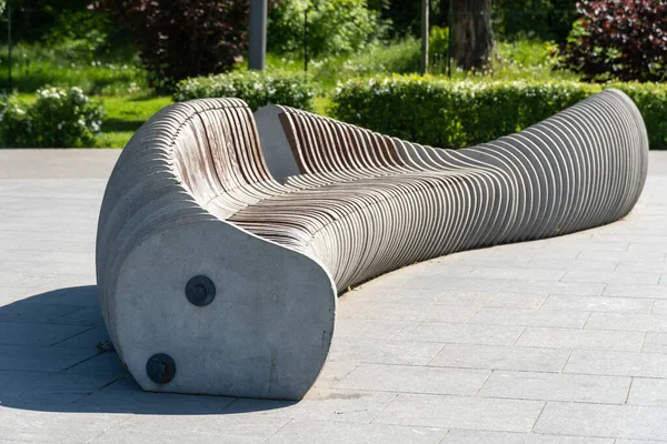 stock image Comfortable wooden bench in city park. Design of brown stationary seat for leisure. Exterior empty park bench. Geometry on nature and place to rest. Furniture in parts material. Decoration in garden.