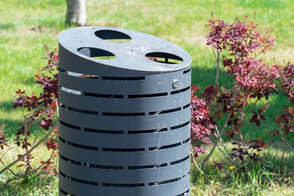 Stock image Stylish trash bin in the park. Modern garbage can for clean environment. Metal steel dustbin on city streets. Design dumpster outside. Cleanliness and tidiness in the garden. are for nature.