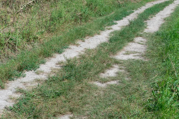 Diagonal tire pattern of quad bike on dirt road. Track imprint of quadricycle. Texture off road. Path of dirt mounds close up. Driveway.