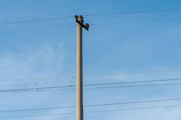 青空の背景に電化された鉄道ポール 鉄道トラックに沿って柱上の電源ライン キャタリーワイヤーの技術 電圧システムの詳細構造 鉄道の設備について — ストック写真
