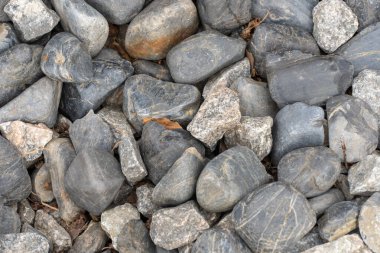 Park ve bahçe tasarımı için gri taş yığını. Geometrik çakıl taşları yakın plan. Doku çakılları ve doğa taşı arka planı. Yuvarlak mineral.