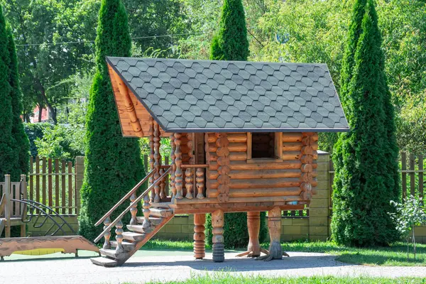 stock image Wooden hut on chicken legs on playground. Fairytale character is house of baba yaga. Entertainment and games for children in park. Mystical and fairy being grandmother yaga in slavic folklore.