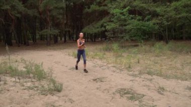 Yetişkin kadın kardiyo sporu yapıyor ve kozalaklı ormanda koşuyor. Fitness kızlarının sağlık koşusu açık havada eğitimdir. Koşu antrenmanı ve sağlıklı yaşam tarzı kavramı. Atletik genç yetişkin yolu.