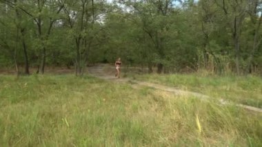 Yetişkin kadın kardiyo sporu ve sazlıkta koşuyor. Fitness kızlarının sağlık koşusu açık havada eğitimdir. Koşu antrenmanı ve sağlıklı yaşam tarzı kavramı. Atletik genç yetişkin yolu.