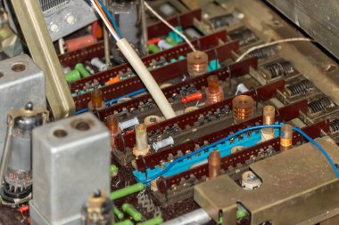Eski elektronik parçalar ve devre kartı. Renkli kablolu elektronik cihaz. Eski devre kartı detayı. Bir sürü kablosu olan elektrik bileşeni. Kontrol panelinin eski bağlantısının karmaşıklığı.