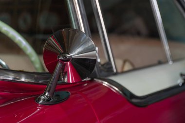 Klasik antika arabanın dikiz aynası. Yakın plan. Kırmızı otomobil klasik stilinde yuvarlak kanat aynası. Eski moda araç parçası.