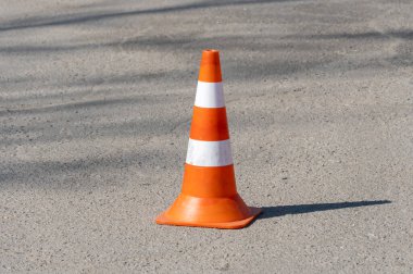 Turuncu beyaz trafik konileri dikkat ve güvenlik sinyali veriyor. Trafik konisi asfalt yoldaki uyarıların bir görüntüsü. Yol uyarı levhası güvenliği yakın plan. Dikkat!.