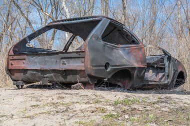 Yakın planda yanmış ve paslı bir araba. Kaza ve felaket sonucu hasar görmüş bir otomobil. Çalıntı ve sonradan terk edilmiş eski bir ulaşım suçu. Acil durum kundaklama ve itfaiye arabası sigortası.