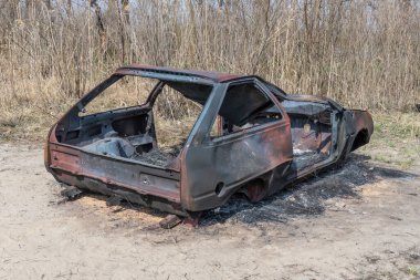 Yakın planda yanmış ve paslı bir araba. Kaza ve felaket sonucu hasar görmüş bir otomobil. Çalıntı ve sonradan terk edilmiş eski bir ulaşım suçu. Acil durum kundaklama ve itfaiye arabası sigortası.