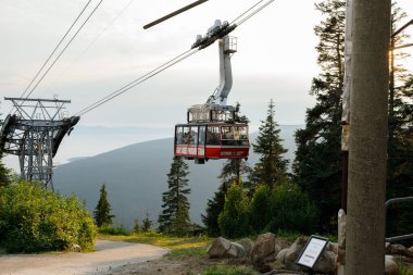 Vancouver, Kanada - 5 Ağustos 2023: Grouse Mountain 'ın Skyride gondolunun çarpıcı bir günbatımına karşı manzarası