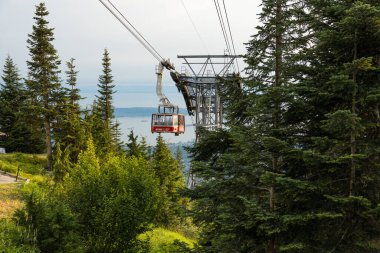 Vancouver, Kanada - 5 Ağustos 2023: Grouse Mountain 'ın Skyride gondolunun çarpıcı bir günbatımına karşı manzarası