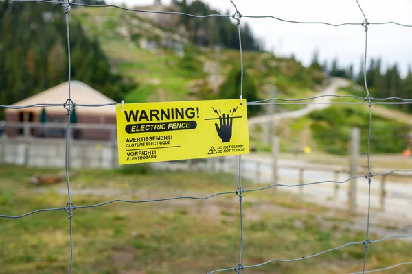 View of a warning sign about an electric fence within the Grizzly Bear Habitat at the top of Grouse Mountain in Vancouver