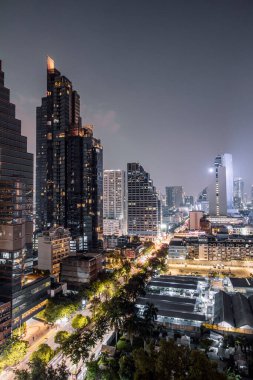 Bangkok, Tayland - 3 Kasım 2023: Silom İlçesi 'nin nefes kesici manzarası gece aydınlandı, Bangkok, Tayland' daki bir çatı noktasından çekildi
