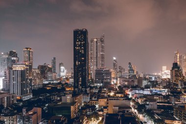 Bangkok, Tayland - 3 Kasım 2023: Silom İlçesi 'nin nefes kesici manzarası gece aydınlandı, Bangkok, Tayland' daki bir çatı noktasından çekildi