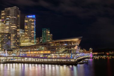 Vancouver, Kanada - 3 Ocak 2024: Vancouver Kongre Merkezi İkonik eğimli çatı tasarımı ile Shaw Kulesi de dahil olmak üzere aydınlanmış şehir merkezindeki gökdelenlere karşı