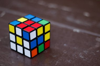Vancouver, Kanada - 12019 Ekim: Renkli bir Rubik küp bulmacasını karanlık arka plana karşı manipüle eden eller
