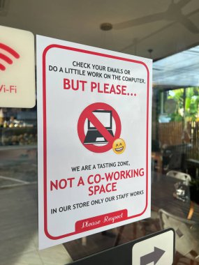 Vitrin levhası kibarca bunun birlikte çalışma alanı olmadığını gösteriyor, içinde çalışma alanı politikası hakkında dostane ama net mesajlar kullanarak, emojili Wi-Fi sembolü ve dizüstü bilgisayar yasaklama simgesi yer alıyor