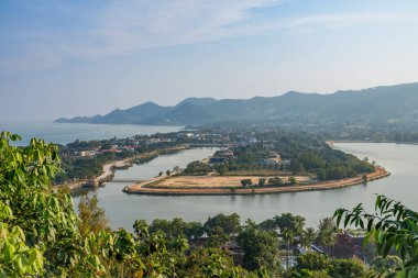 Expansive view of Chaweng Lake from Kao Hua Jook Pagoda in Ko Samui, featuring its distinctive curved shoreline, surrounding developments, and mountain backdrop against the Gulf of Thailand clipart