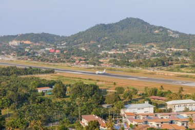 Samui, Tayland - 12 Şubat 2025: Kao Hua Jook Pagoda 'dan panoramik manzara Ko Samui Havaalanı pistinde çeşitli uçaklar, yemyeşil tropikal ormanlarla çevrili