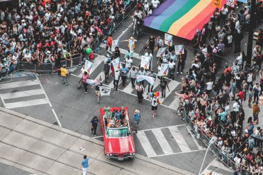 Toronto, Kanada - 26 Haziran 2017: Toronto Onur Yürüyüşü şehir merkezindeki sokaklarda Yonge Caddesi 'nde büyük bir kalabalığın oluşturduğu devasa bir gökkuşağı bayrağını gösteriyor