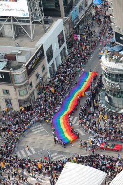 Toronto, Kanada - 26 Haziran 2017: Toronto Onur Yürüyüşü şehir merkezindeki sokaklarda Yonge Caddesi 'nde büyük bir kalabalığın oluşturduğu devasa bir gökkuşağı bayrağını gösteriyor