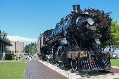 Kingston, Canada - August 13,2017: Historic black steam locomotive #1095 displayed on tracks in Kingston park setting clipart