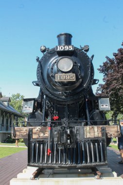 Kingston, Canada - August 13,2017: Historic black steam locomotive #1095 displayed on tracks in Kingston park setting clipart