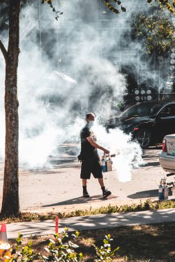 Vancouver, Canada - July 20,2021: Behind-the-scenes of Supergirl TV show filming in Vancouver showing special effects with white smoke/fog, crew members, equipment clipart