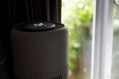 Vancouver, Kanada - 18 Mart 2025 Philips hava temizleyicisi yanında siyah perdelerle pencere kenarına yerleştirildi
