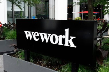Vancouver, Kanada - 21 Haziran 2025: Vancouver 'daki WeWork tabelası, modern binaların ve yeşilliklerin arka planına karşı kurulmuştur