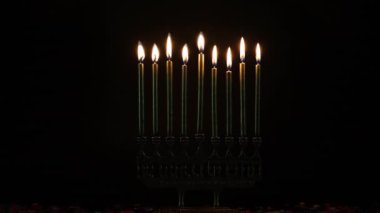 Hanukkah sırasında, karanlık odadaki menoralarda mumlar yakılıyor..