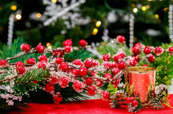 Rote Beeren Und Eine Brennende Kerze Vor Weihnachtlichem Hintergrund — Stockfoto