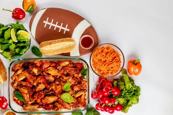 Wings come with a dip sauce and salad for football game party.
