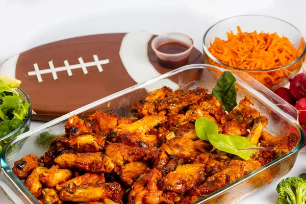 For football game party, wings are served with dip sauce and salad.