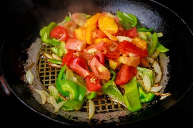 Demir tavada kızartılmış renkli sebzeler.